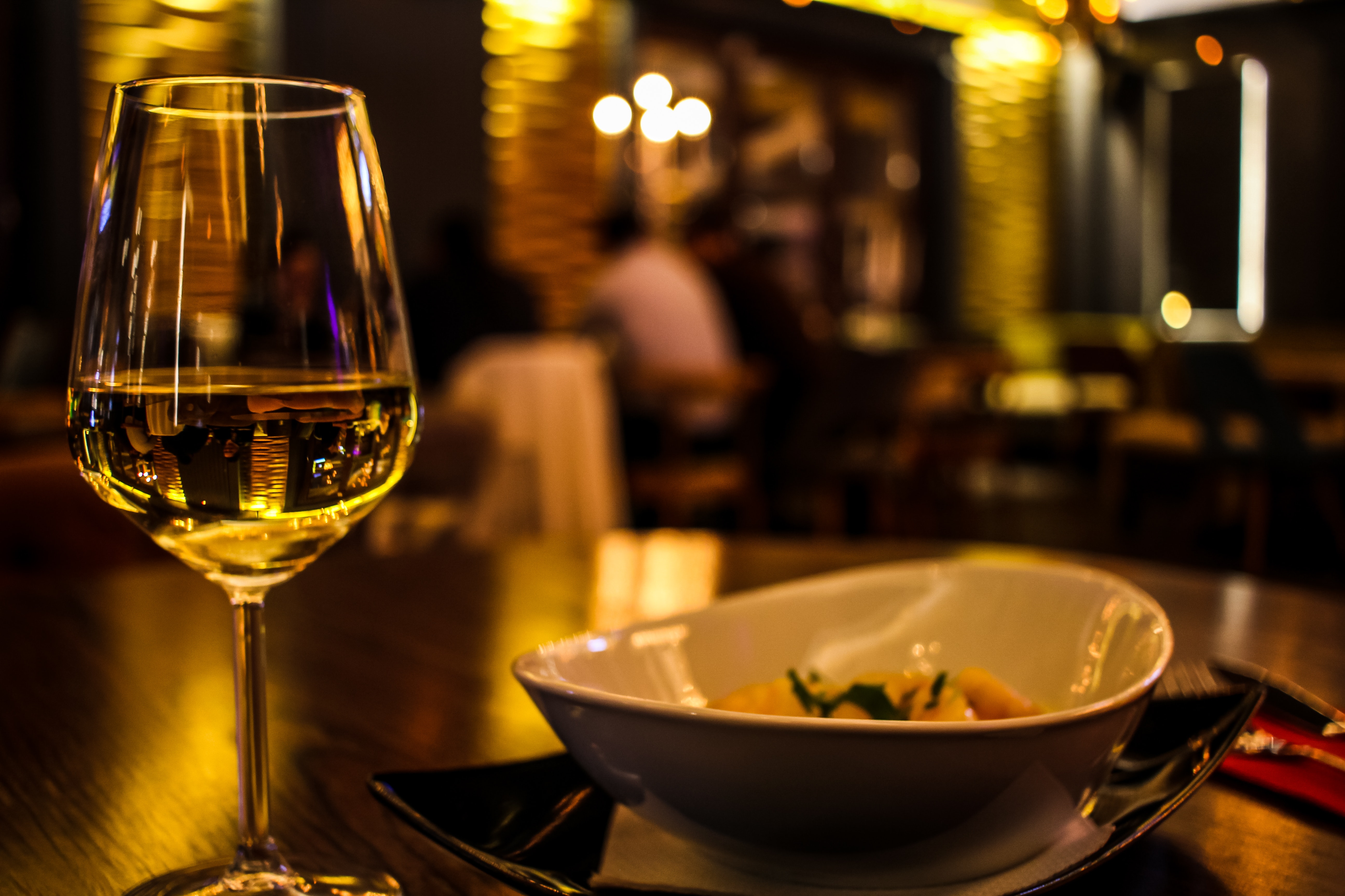 glass of wine and dish of food in an upscale restaurant